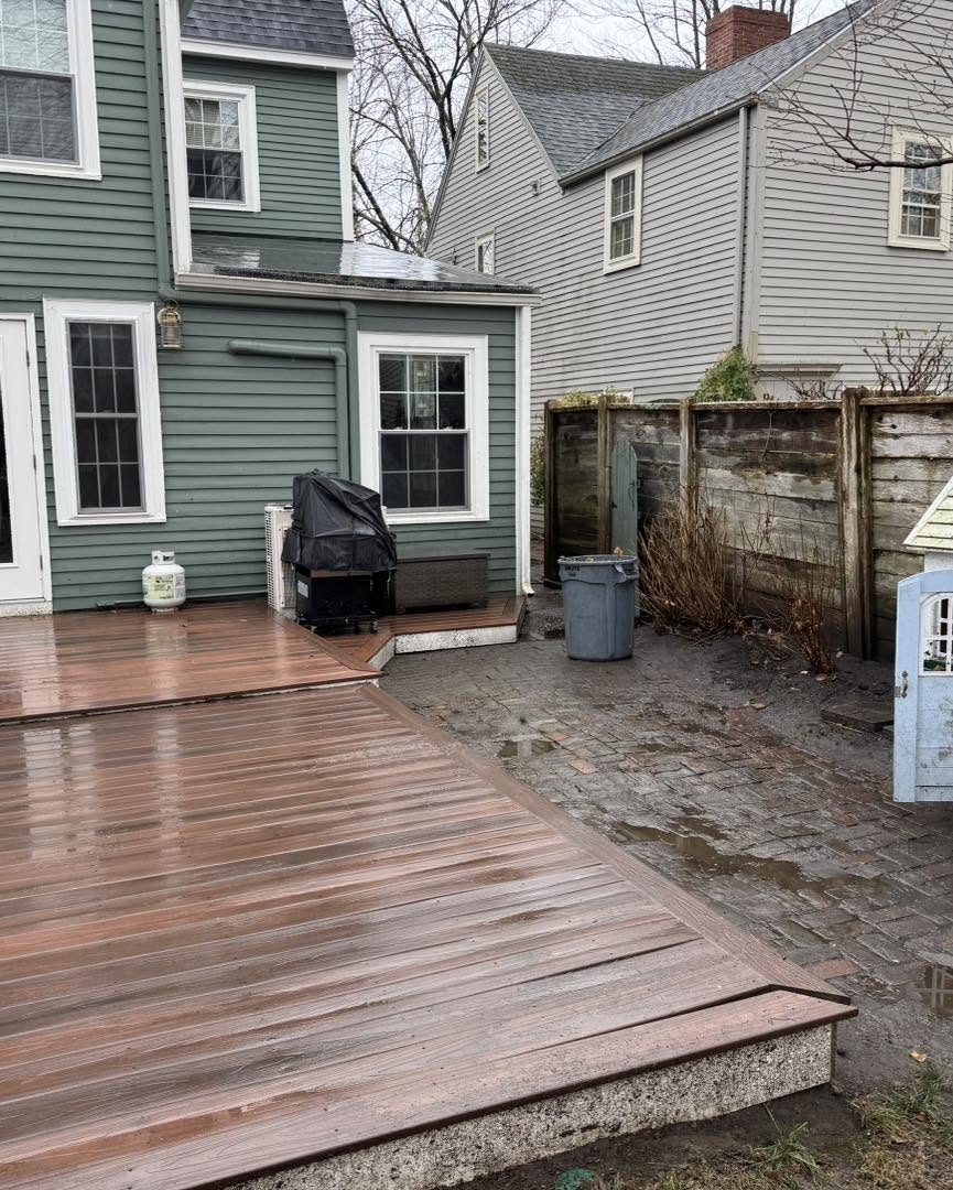A backyard deck and lawn cleared of leaves after a fall cleanup
